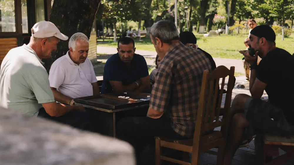 Ältere Männer spielen gemeinsam Backgammon im Park